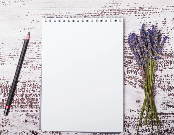 Empty notepad, pensil and lavender flowers on the whitw wooden b — Stock Photo, Image