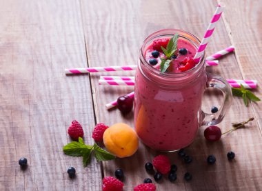 Yaz meyveleri ve meyve wo üzerinde bir cam kupa ile güler yüzlü