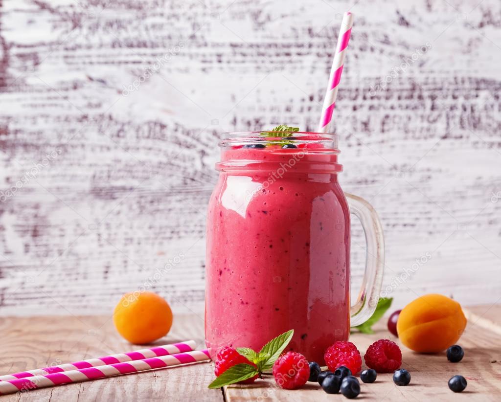 Summer fruits and berries smoothie in a glass mug