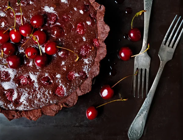 Schokoladentarte mit Ganache und Kirsche. Foto im dunklen Stil. — Stockfoto