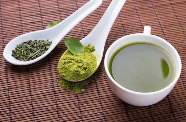Grüner Tee auf der braunen Matte — Stockfoto