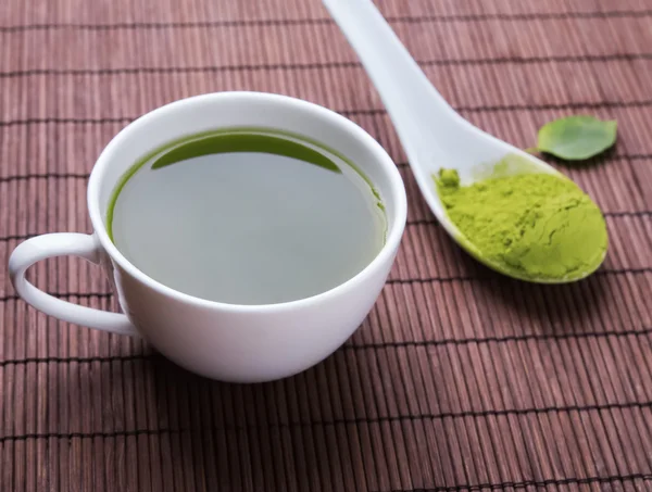 Matcha chá em uma xícara branca no tapete — Fotografia de Stock