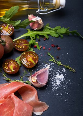 Kiraz domates, jambon, roka ve baharat kara tahta üzerinde