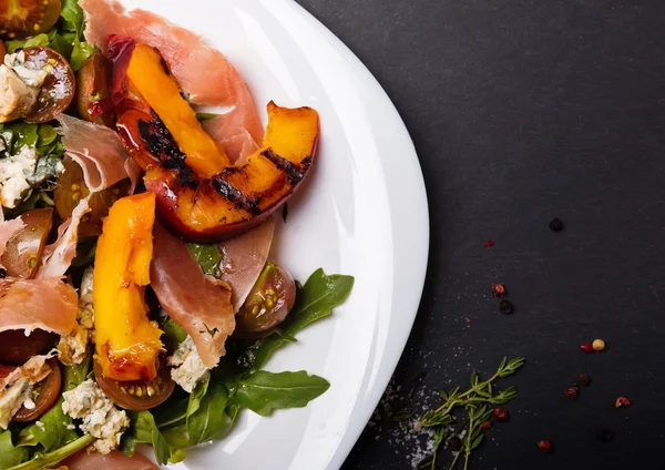 Köstlicher Salat mit gegrillten Pfirsichen und Schinken — Stockfoto