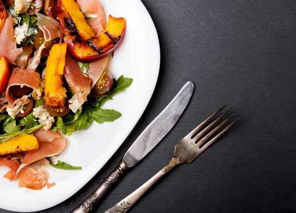 Dark Style Foto von köstlichem Salat mit gegrillten Pfirsichen — Stockfoto