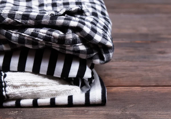 Stack of black and white clothes with striped and checkered patt — Stock Photo, Image