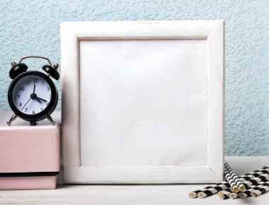 Boş beyaz bir çerçeve, siyah saat ve kağıt payet