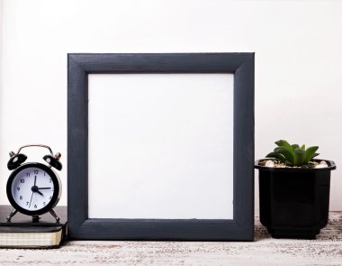 Boş koyu gri çerçeve, saat ve etli bitki