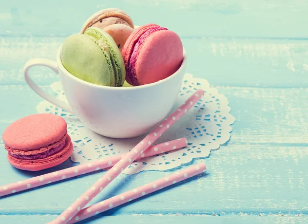 Macarons na xícara na mesa azul, foto tonificada — Fotografia de Stock