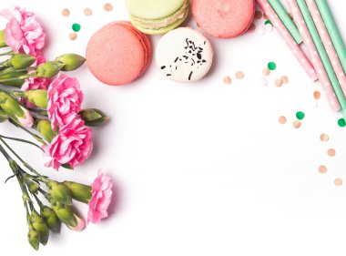 Çiçekler, beyaz arka plan üzerinde macarons ve kağıt payet