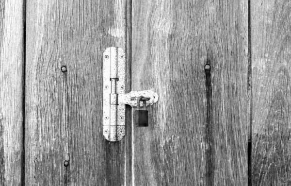 White painted wooden door padlock on a light background washed wood