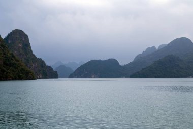 Vietnam, Ha Long Körfezi 'ndeki dağ kireçtaşı adaları sisli bir gün.