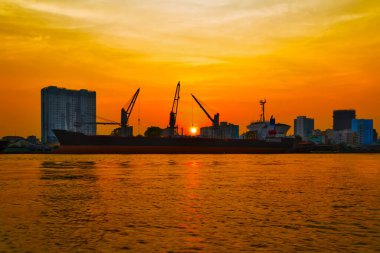 Kargo Turnaları konteynırları limana yükleniyor. Lojistik ithalat terminali. Günbatımı turuncu ufuk