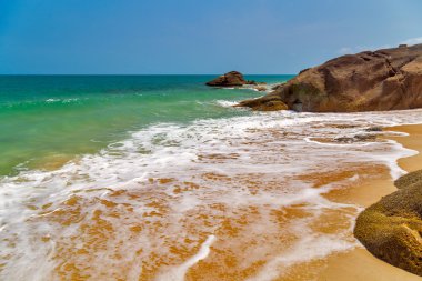 Tropikal deniz üzerinde kayalık plaj.