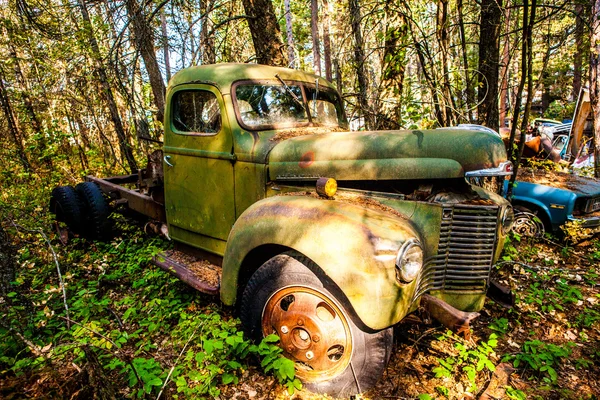 Velho carro enferrujado no ferro-velho — Fotografia de Stock