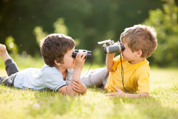 Duas crianças brincam com binóculos — Fotografia de Stock