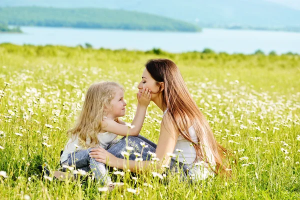 Moeder en dochter op gebied van madeliefjes — Stockfoto