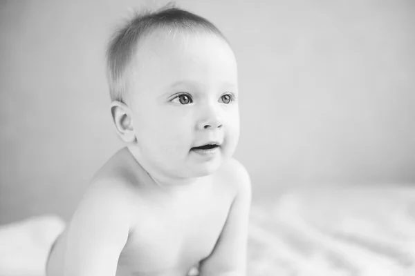 Blue-eyed baby sitting on the sofa — Stock Photo, Image