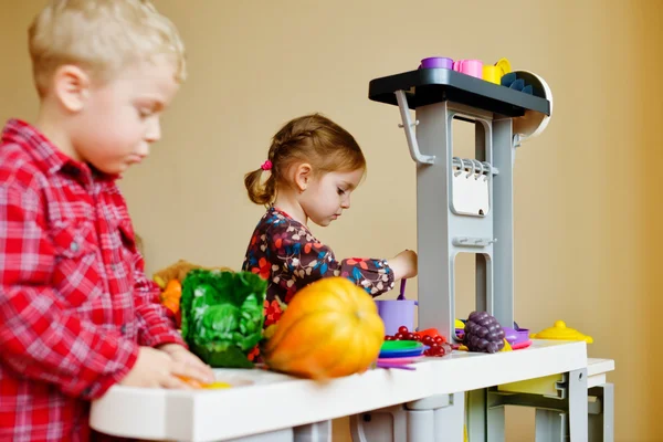 Children playing toy kitchen — Stock Photo, Image