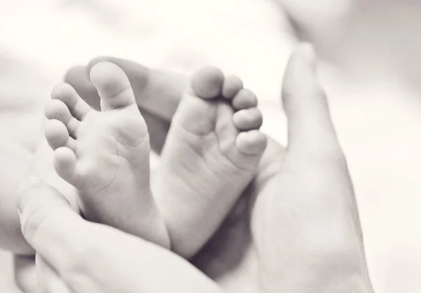 Newborn's foot in the mother hand — Stock Photo, Image