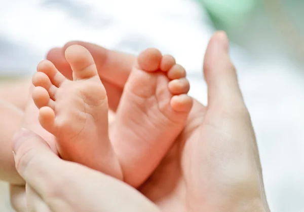 Newborn's foot in the mother hand — Stock Photo, Image