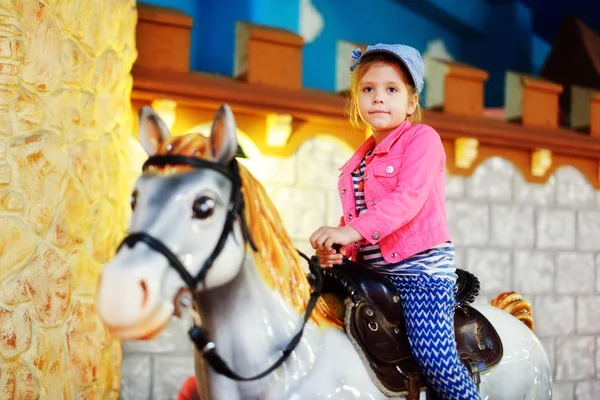 Girl riding   a carousel horse — Stock Photo, Image