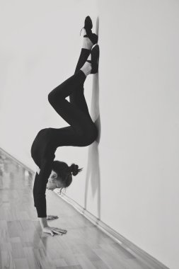 Dans stüdyosu ayakta baş aşağı duvarın yanında esnek skinny kız