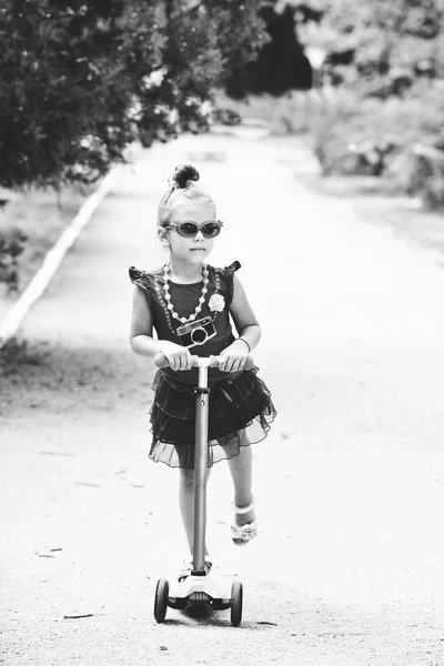 Pequena menina da moda na scooter — Fotografia de Stock