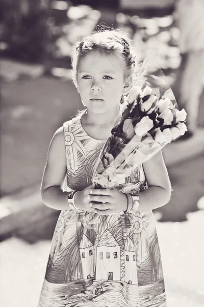 Kleines Mädchen mit Blumen — Stockfoto