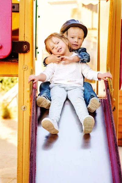 Två Roliga Barn Rutschkanan Lekplatsen — Stockfoto