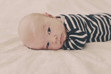 Bebek yatakta karnının üstünde yatıyor.