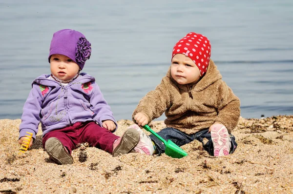 两个滑稽的幼儿在海滩上玩沙子 — 图库照片