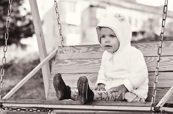 Смішна дівчинка-малюк на гойдалці — стокове фото
