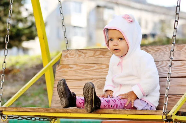 Engraçada criança menina no balanço — Fotografia de Stock