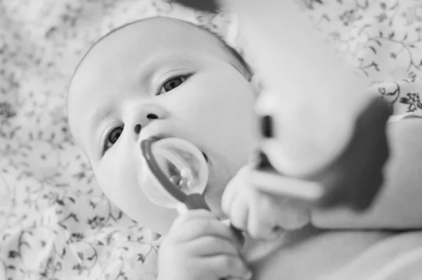Söta baby bita en leksak — Stockfoto
