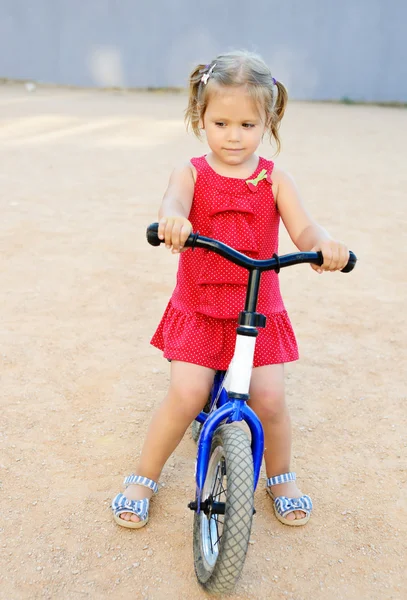 Girl on a training bike — Stock Photo, Image