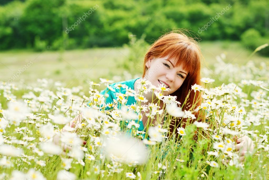 redhead woman   in field of daisies