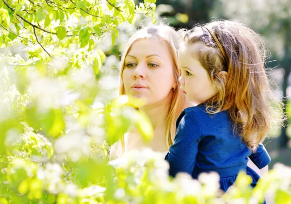Mother and girl in blossom garden — Stock Photo, Image