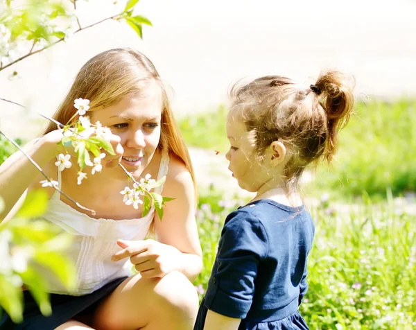Mother and girl in blossom garden — Stock Photo, Image