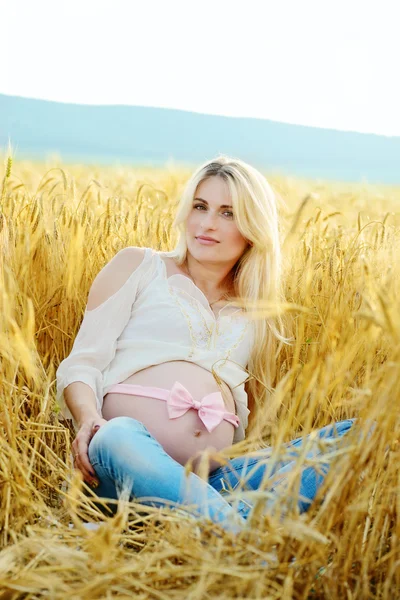 Беременная женщина на пшеничном поле — стоковое фото