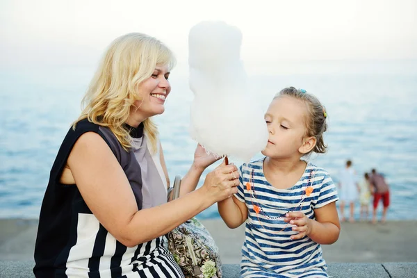 Mulher e menina comendo um algodão doce — Fotografia de Stock