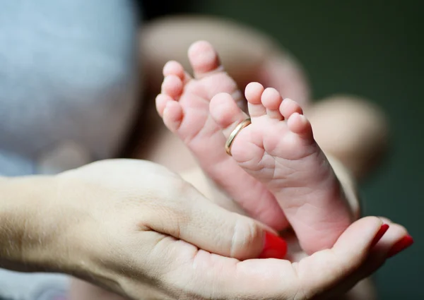 Newborn's foot in the mother hand — Stock Photo, Image