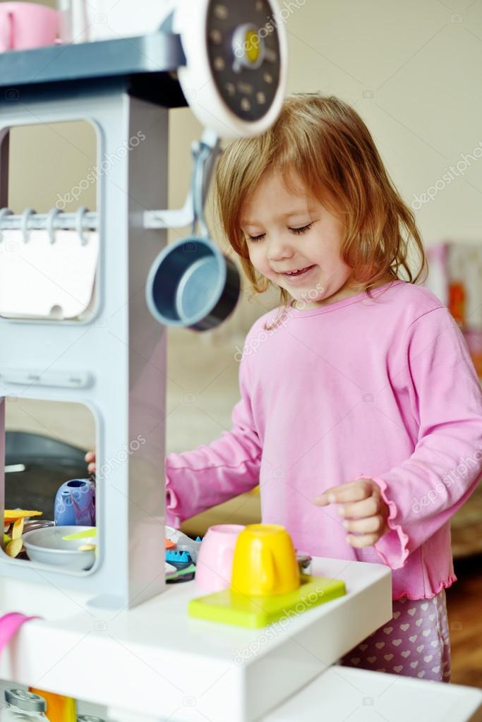girl playing with kitchen