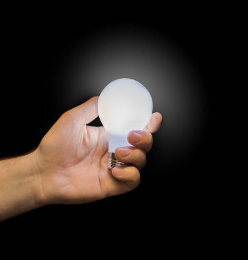 Eldeki aydınlatma lambası siyah arkaplanda izole edildi