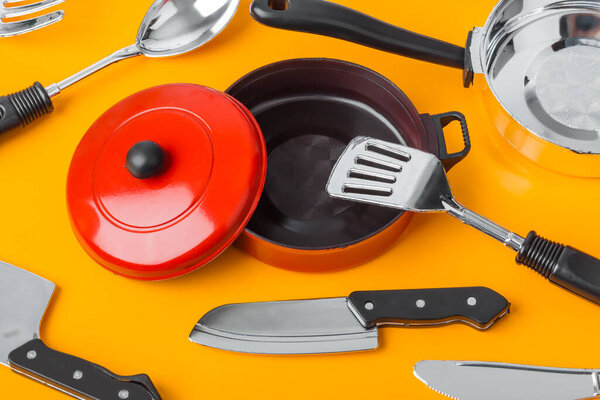Toy kitchenware on orange background