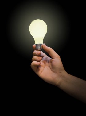 Eldeki aydınlatma lambası siyah arkaplanda izole edildi