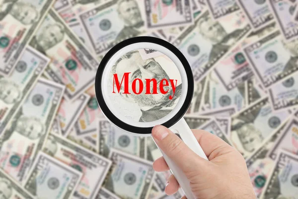 Hand with magnifying glass and Money - business background