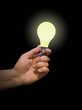 Eldeki aydınlatma lambası siyah arkaplanda izole edildi