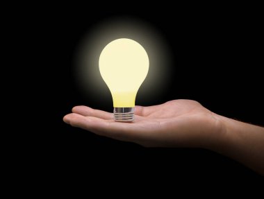 Eldeki aydınlatma lambası siyah arkaplanda izole edildi