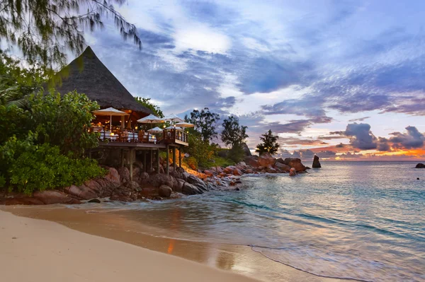 Cafe on Seychelles tropical beach at sunset — Stock Photo, Image